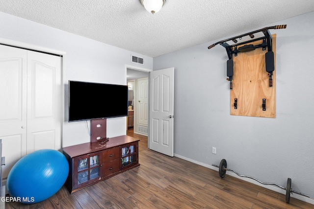 12090 Sterling Mary Way, El Paso, TX 79936 - unfurnished bedroom featuring a closet, wood finished floors, and a textured ceiling