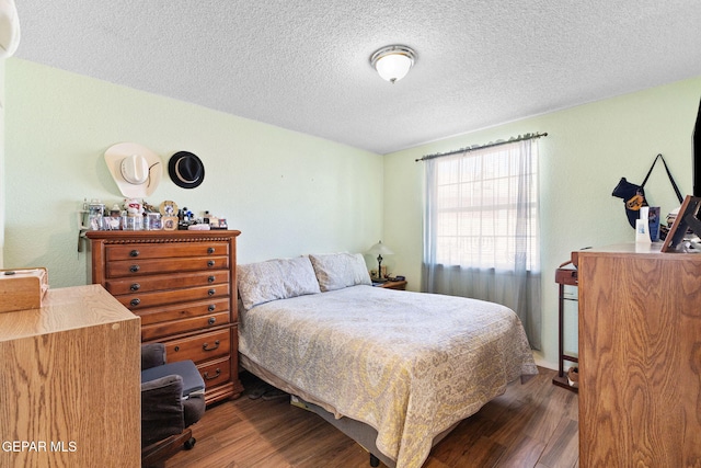 12090 Sterling Mary Way, El Paso, TX 79936 - bedroom featuring dark wood-type flooring and a textured ceiling