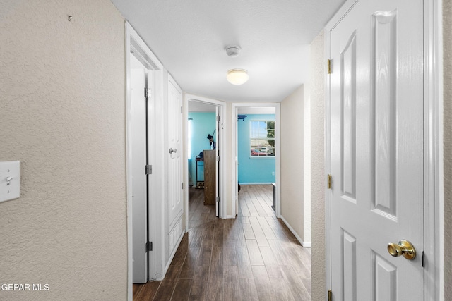 12090 Sterling Mary Way, El Paso, TX 79936 - hall featuring a textured wall and dark wood-style flooring