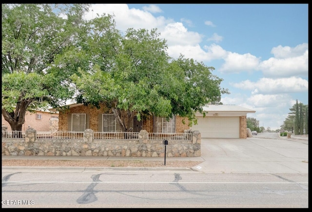 4821 Round Rock Dr, El Paso, TX 79924 - view of property hidden behind natural elements featuring concrete driveway, a garage, and brick siding