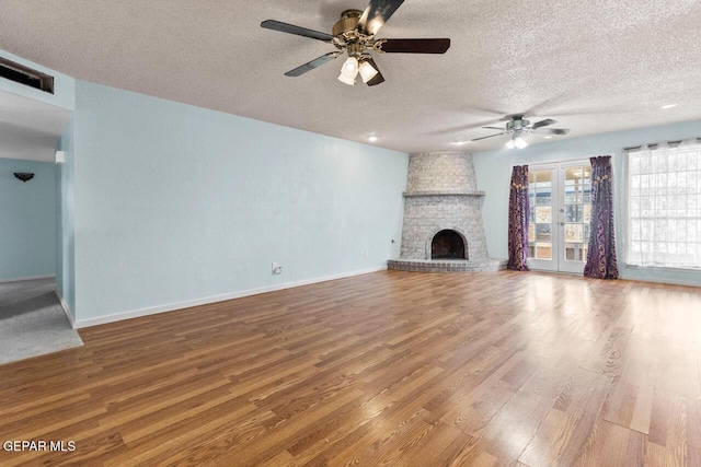 4821 Round Rock Dr, El Paso, TX 79924 - unfurnished living room featuring ceiling fan, a textured ceiling, wood finished floors, and a fireplace