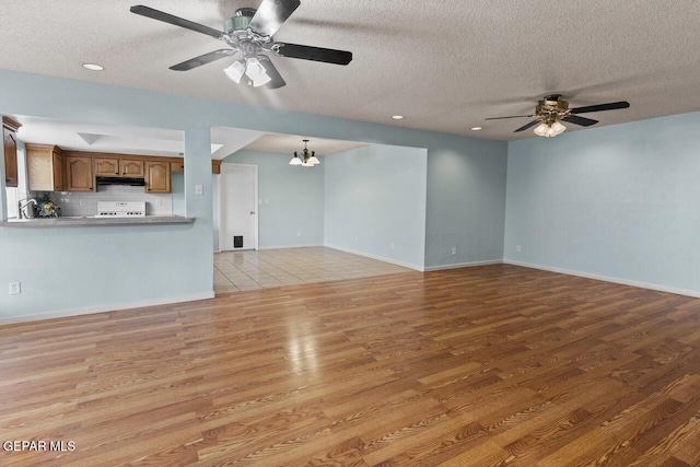 4821 Round Rock Dr, El Paso, TX 79924 - unfurnished living room with a ceiling fan, wood finished floors, a textured ceiling, and a chandelier