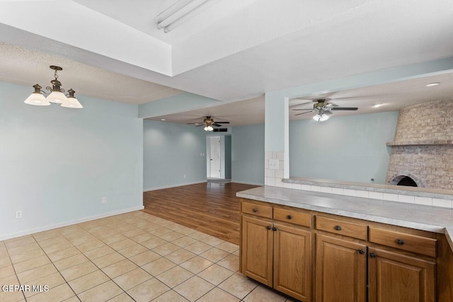 4821 Round Rock Dr, El Paso, TX 79924 - kitchen featuring open floor plan, a ceiling fan, brown cabinets, and light countertops