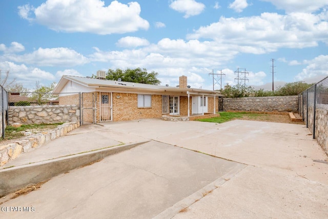4821 Round Rock Dr, El Paso, TX 79924 - rear view of house with a chimney, a fenced backyard, a gate, brick siding, and a patio area