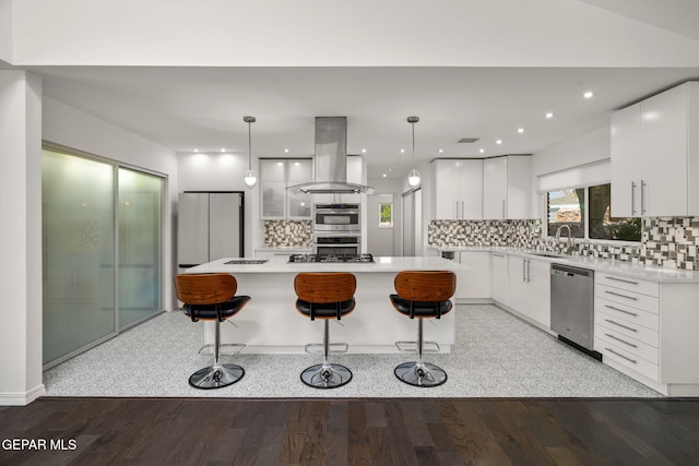 10121 Monaco Dr, El Paso, TX 79925 - kitchen with appliances with stainless steel finishes, island exhaust hood, a kitchen island, a kitchen bar, and white cabinetry
