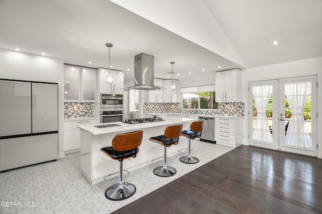 10121 Monaco Dr, El Paso, TX 79925 - kitchen featuring island exhaust hood, appliances with stainless steel finishes, white cabinets, light countertops, and a breakfast bar area