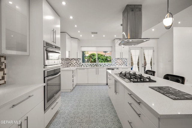 10121 Monaco Dr, El Paso, TX 79925 - kitchen with stainless steel appliances, island range hood, decorative backsplash, white cabinets, and recessed lighting
