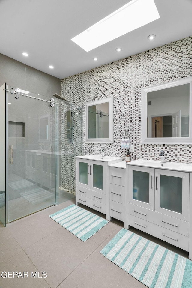10121 Monaco Dr, El Paso, TX 79925 - full bath with a skylight, a shower stall, two vanities, recessed lighting, and decorative backsplash