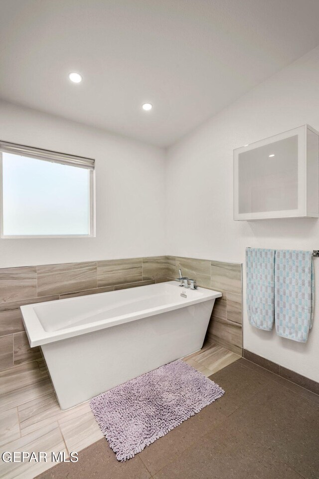 10121 Monaco Dr, El Paso, TX 79925 - full bath with tile walls, a freestanding bath, wainscoting, and recessed lighting