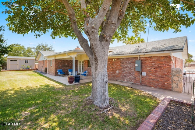 10121 Monaco Dr, El Paso, TX 79925 - rear view of house with brick siding, a patio, a shingled roof, and a storage unit
