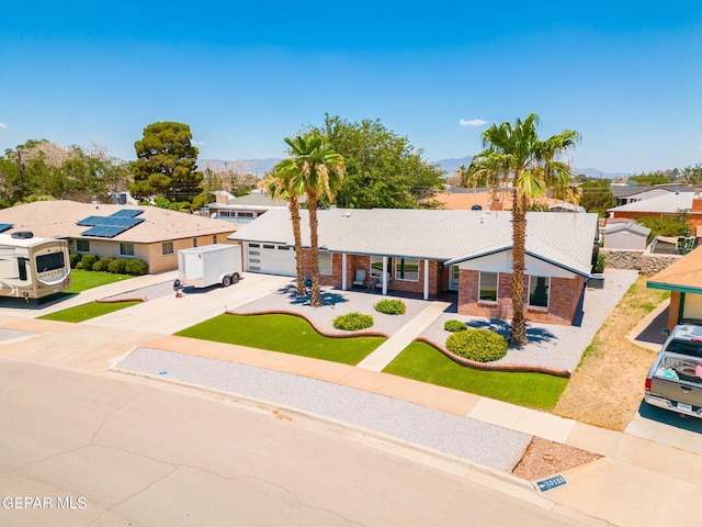 10121 Monaco Dr, El Paso, TX 79925 - ranch-style home with driveway, brick siding, a residential view, a mountain view, and an attached garage