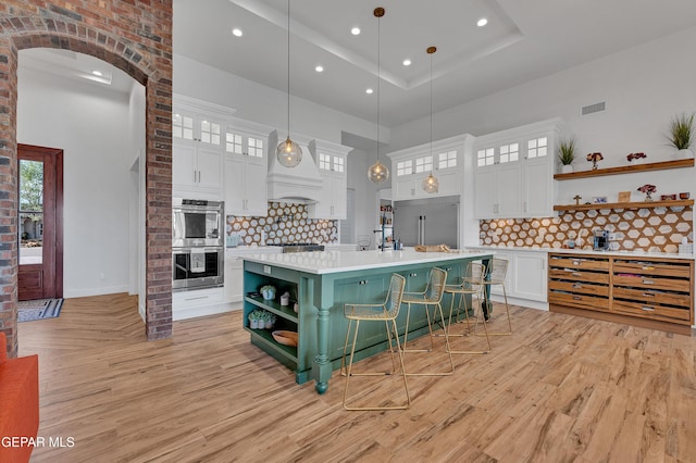 1042 Castillo Ct, El Paso, TX 79932 - kitchen featuring open shelves, stainless steel appliances, light wood finished floors, a towering ceiling, and light countertops