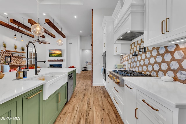 1042 Castillo Ct, El Paso, TX 79932 - kitchen with green cabinetry, appliances with stainless steel finishes, custom exhaust hood, light wood-style flooring, and white cabinets