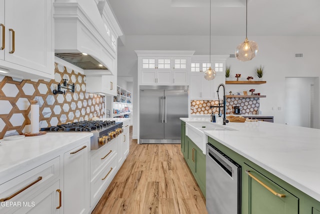 1042 Castillo Ct, El Paso, TX 79932 - kitchen with stainless steel appliances, green cabinetry, custom range hood, light countertops, and white cabinets