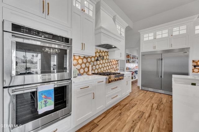 1042 Castillo Ct, El Paso, TX 79932 - kitchen featuring appliances with stainless steel finishes, white cabinets, light wood finished floors, and decorative backsplash