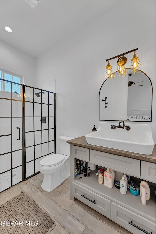 1042 Castillo Ct, El Paso, TX 79932 - bathroom with a stall shower, vanity, wood finished floors, and ceiling fan