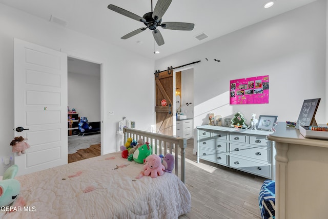 1042 Castillo Ct, El Paso, TX 79932 - bedroom featuring wood finished floors, a barn door, recessed lighting, and a ceiling fan