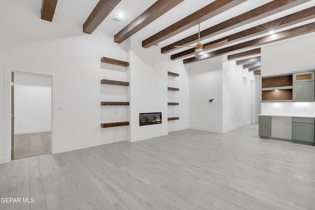 837 Paseo Serra Ct, El Paso, TX 79928 - unfurnished living room featuring beamed ceiling, light wood-style floors, and a glass covered fireplace