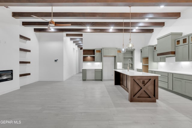 837 Paseo Serra Ct, El Paso, TX 79928 - kitchen featuring beamed ceiling, light wood-type flooring, a kitchen island with sink, pendant lighting, and light countertops