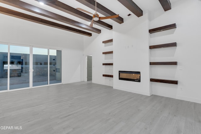837 Paseo Serra Ct, El Paso, TX 79928 - unfurnished living room with beam ceiling, a glass covered fireplace, wood finished floors, ceiling fan, and high vaulted ceiling