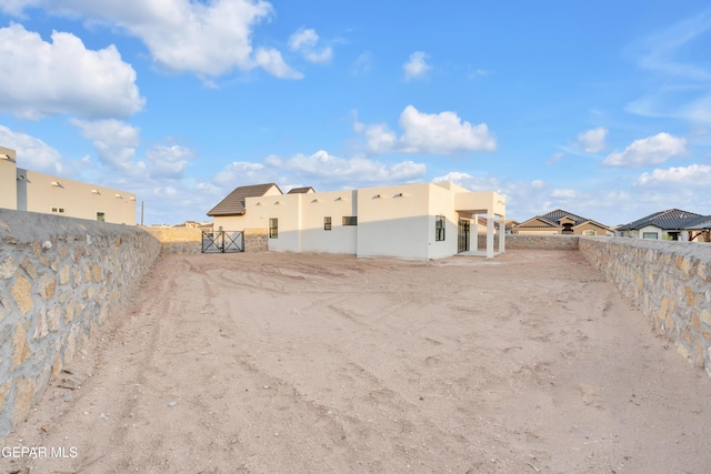 837 Paseo Serra Ct, El Paso, TX 79928 - rear view of house featuring stucco siding, a fenced backyard, a gate, and a residential view