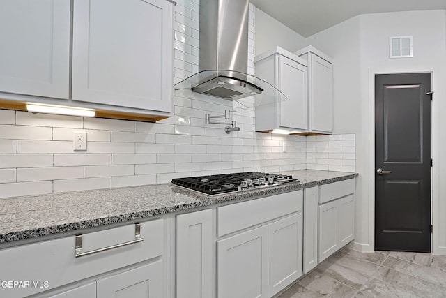 2362 Enchanted Crown Ln, El Paso, TX 79911 - kitchen featuring ventilation hood, stainless steel gas cooktop, light stone countertops, white cabinetry, and decorative backsplash