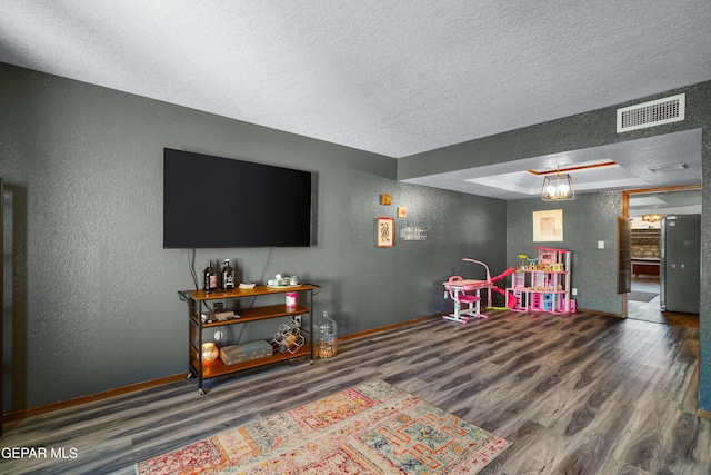 6604 Camino Fuente Dr, El Paso, TX 79912 - playroom featuring a textured wall, wood finished floors, a textured ceiling, and a raised ceiling