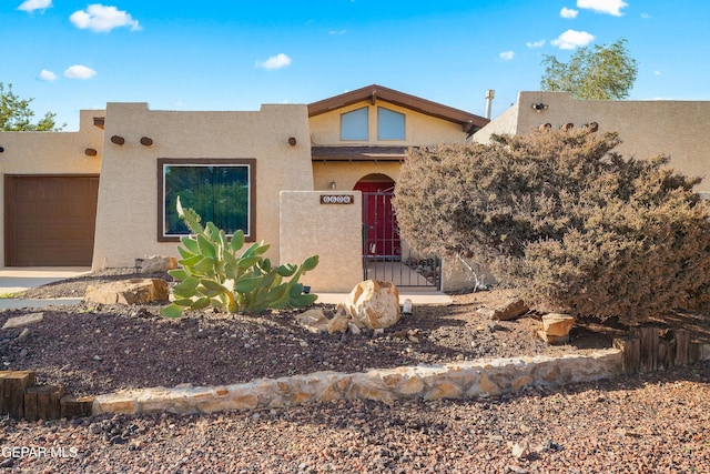 6604 Camino Fuente Dr, El Paso, TX 79912 - pueblo-style home with stucco siding and an attached garage