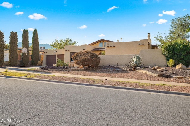 6604 Camino Fuente Dr, El Paso, TX 79912 - adobe home featuring an attached garage, stucco siding, and driveway