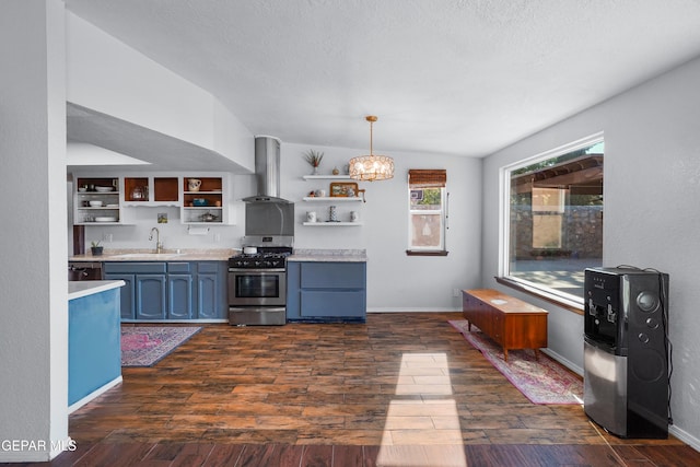 6604 Camino Fuente Dr, El Paso, TX 79912 - kitchen with stainless steel range with gas stovetop, wall chimney range hood, open shelves, light countertops, and a chandelier