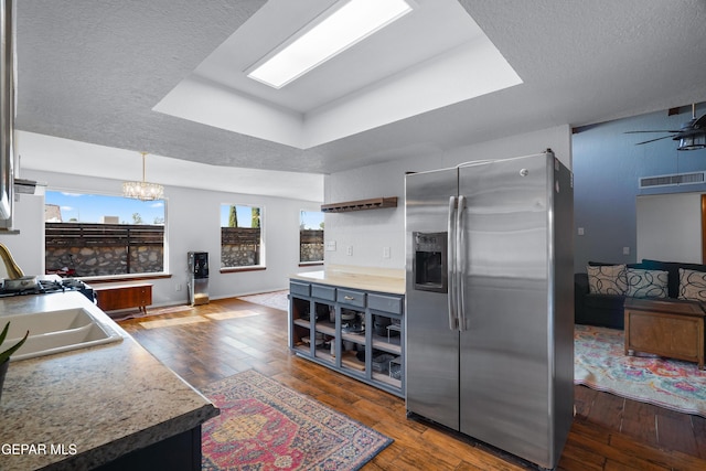 6604 Camino Fuente Dr, El Paso, TX 79912 - kitchen with stainless steel refrigerator with ice dispenser, a tray ceiling, dark wood-style floors, and a textured ceiling