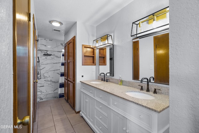 6604 Camino Fuente Dr, El Paso, TX 79912 - full bathroom featuring double vanity, a marble finish shower, tile patterned floors, and a textured wall