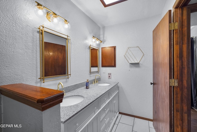 6604 Camino Fuente Dr, El Paso, TX 79912 - full bathroom with double vanity, tile patterned floors, and a textured wall