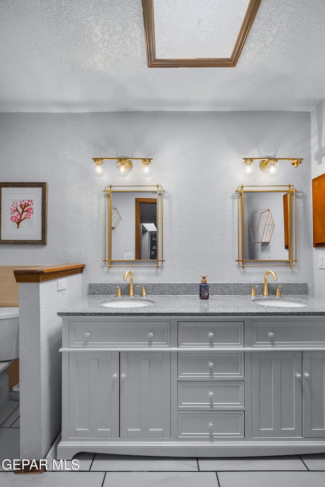 6604 Camino Fuente Dr, El Paso, TX 79912 - full bath with double vanity, a textured ceiling, and tile patterned flooring