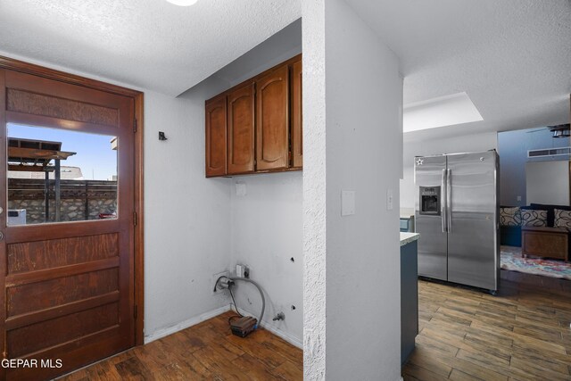 6604 Camino Fuente Dr, El Paso, TX 79912 - laundry area featuring a textured ceiling and wood finished floors