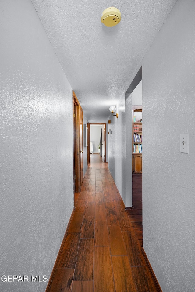 6604 Camino Fuente Dr, El Paso, TX 79912 - hallway featuring wood-type flooring, a textured wall, and a textured ceiling