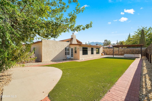 6604 Camino Fuente Dr, El Paso, TX 79912 - rear view of house featuring stucco siding, a fenced backyard, a patio, a chimney, and a mountain view