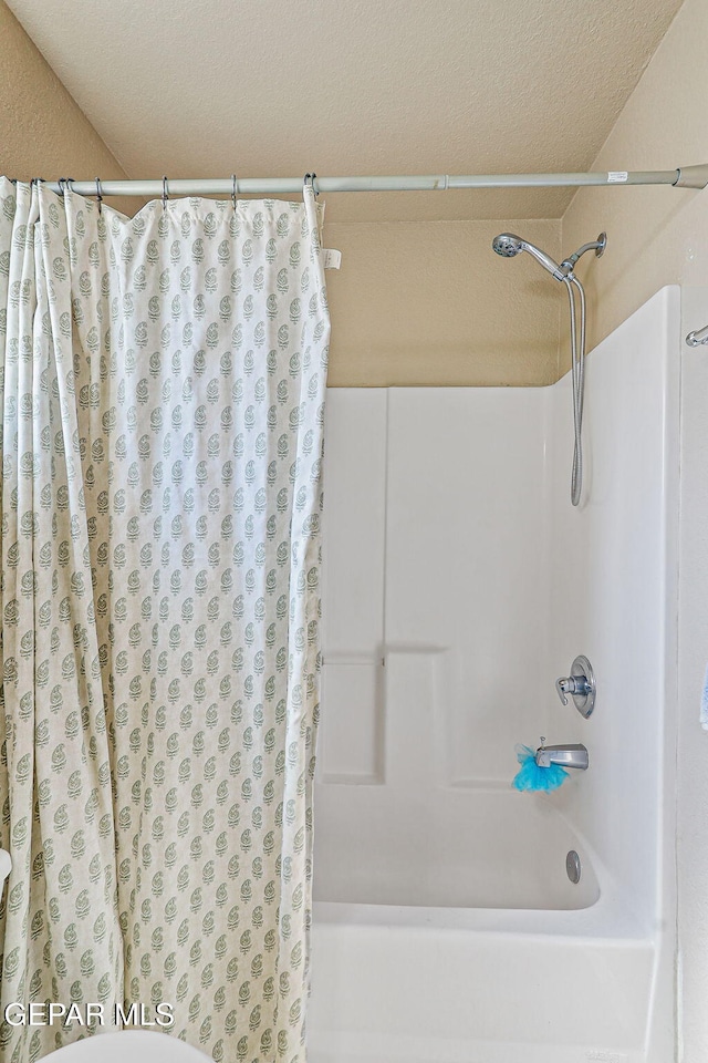 13344 Jonathan Elias Ct, El Paso, TX 79938 - bathroom with shower / bath combo with shower curtain and a textured ceiling