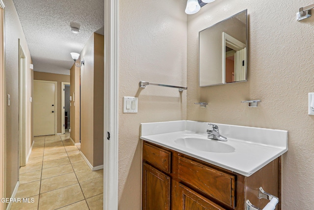 13344 Jonathan Elias Ct, El Paso, TX 79938 - bathroom featuring tile patterned flooring, vanity, a textured ceiling, and a textured wall