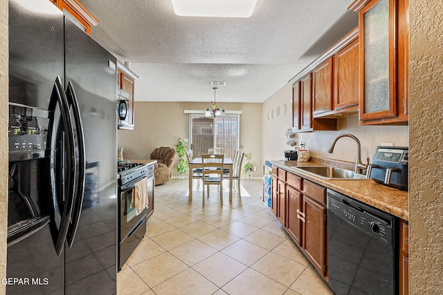 13344 Jonathan Elias Ct, El Paso, TX 79938 - kitchen with black appliances, light tile patterned floors, brown cabinets, a textured ceiling, and light countertops