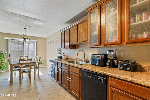 13344 Jonathan Elias Ct, El Paso, TX 79938 - kitchen with black dishwasher, light tile patterned floors, brown cabinets, decorative light fixtures, and a textured ceiling