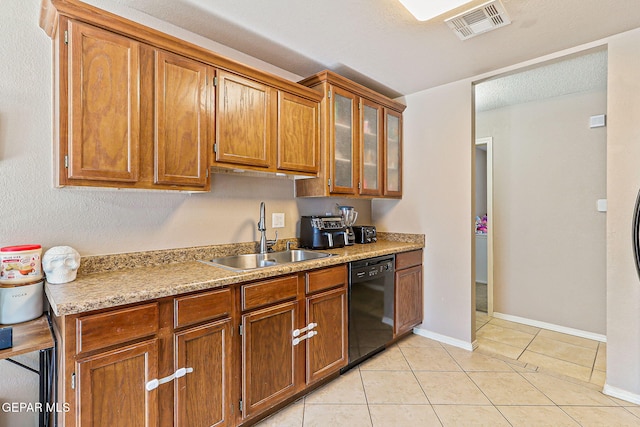 13344 Jonathan Elias Ct, El Paso, TX 79938 - kitchen with black dishwasher, brown cabinets, light tile patterned flooring, and light countertops