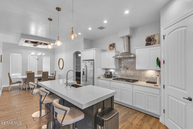 991 Hull St, El Paso, TX 79928 - kitchen featuring stainless steel appliances, wall chimney exhaust hood, light wood-type flooring, decorative backsplash, and recessed lighting