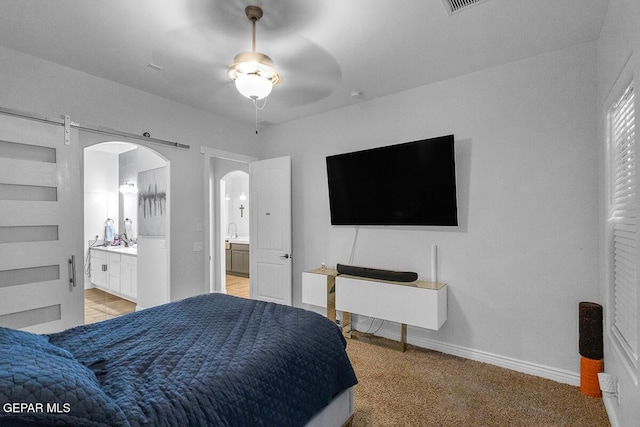991 Hull St, El Paso, TX 79928 - bedroom featuring arched walkways, connected bathroom, and light carpet