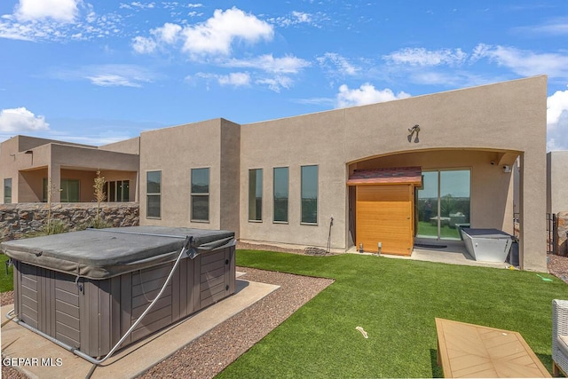 991 Hull St, El Paso, TX 79928 - rear view of house featuring a hot tub, stucco siding, and a lawn