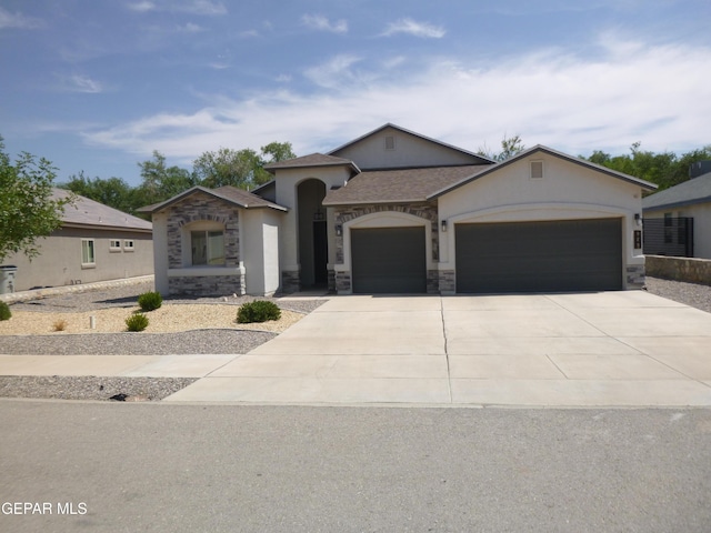 929 Pecos River Dr, El Paso, TX 79932 - view of front of house featuring an attached garage, stucco siding, concrete driveway, and stone siding