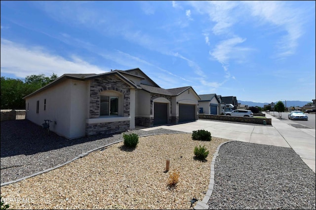 929 Pecos River Dr, El Paso, TX 79932 - view of front facade with concrete driveway, stone siding, stucco siding, and an attached garage