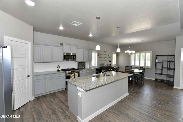 929 Pecos River Dr, El Paso, TX 79932 - kitchen featuring appliances with stainless steel finishes, dark wood-style floors, a chandelier, pendant lighting, and backsplash