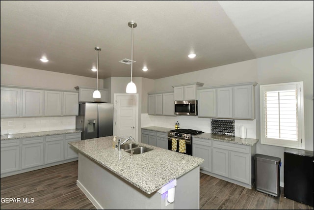 929 Pecos River Dr, El Paso, TX 79932 - kitchen with appliances with stainless steel finishes, dark wood-style flooring, tasteful backsplash, an island with sink, and recessed lighting
