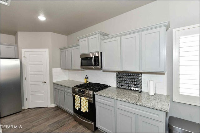 929 Pecos River Dr, El Paso, TX 79932 - kitchen featuring appliances with stainless steel finishes, dark wood finished floors, backsplash, light stone countertops, and recessed lighting